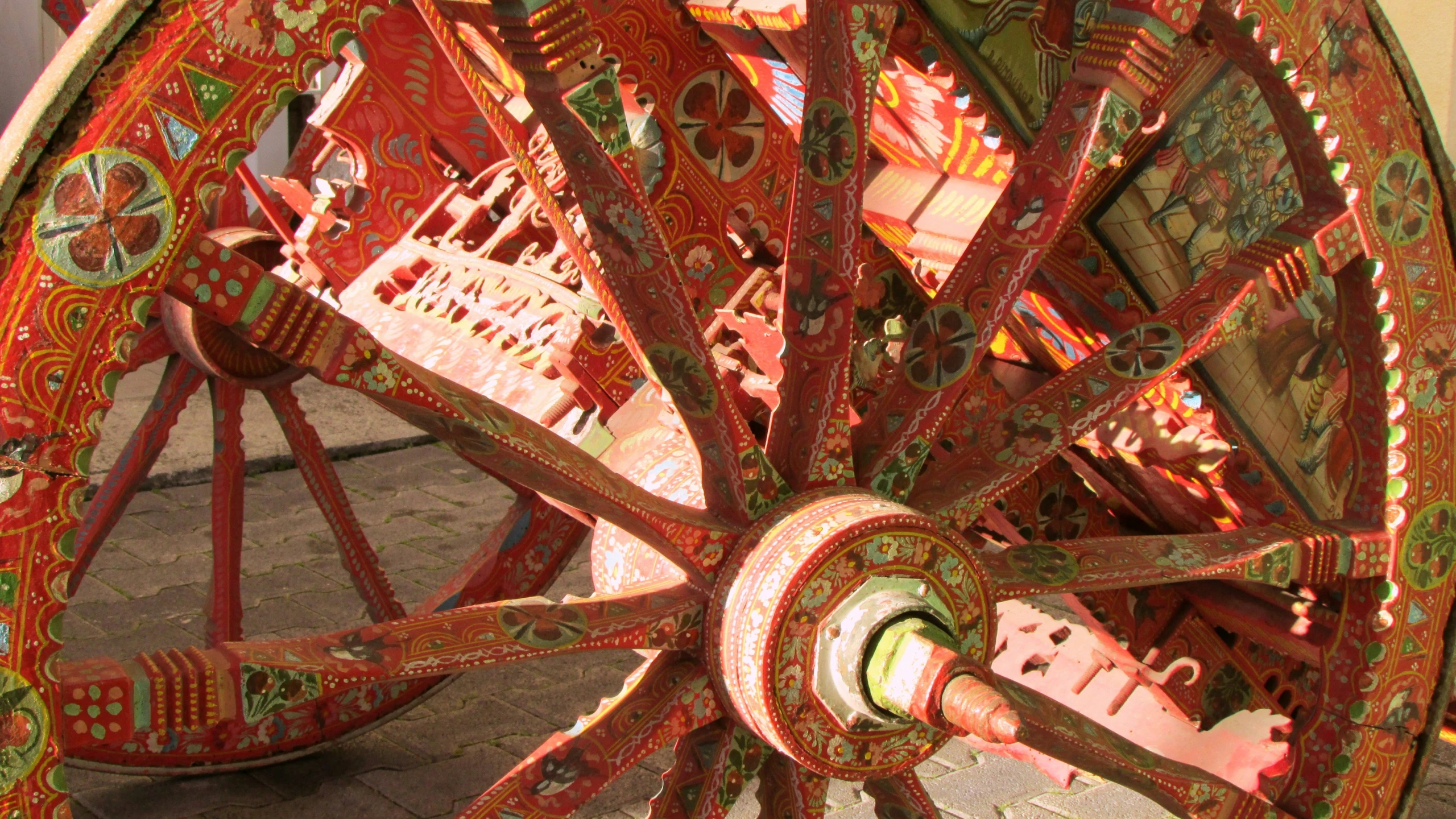 there is a large colorful wooden wheel painted red and green