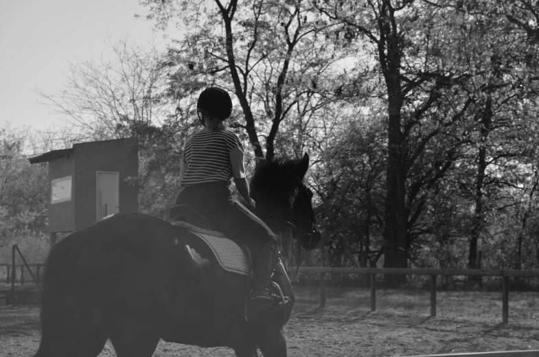 a black and white po of a girl riding a horse