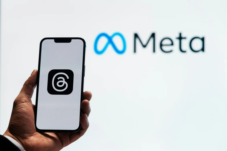 a person holding up their cell phone next to a logo