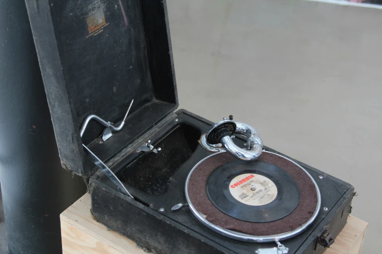 an old record player sitting on a wooden case