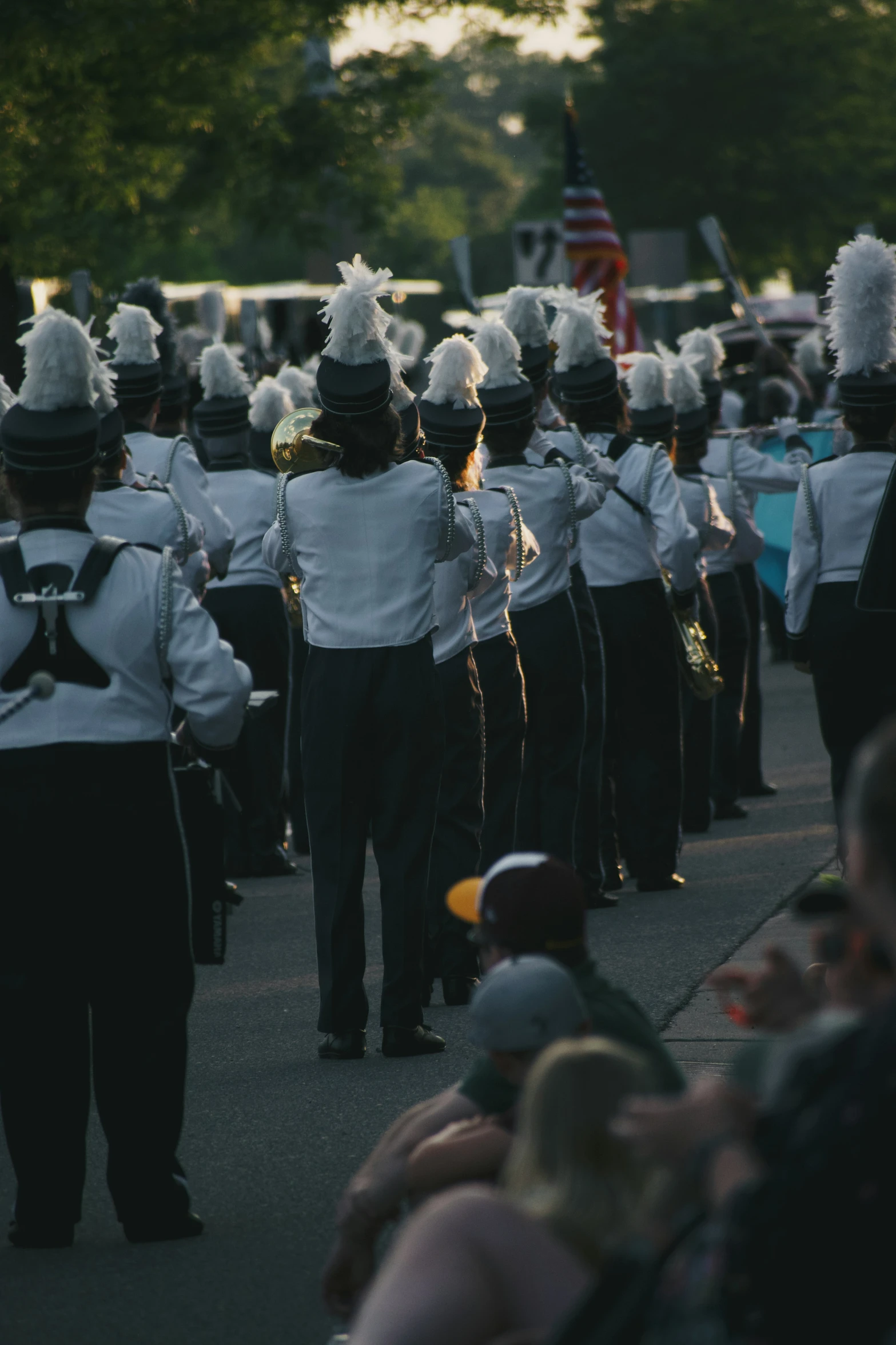 group of marching students walking down street with music equipment on their heads