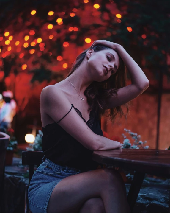 a woman wearing a top and sitting at a table