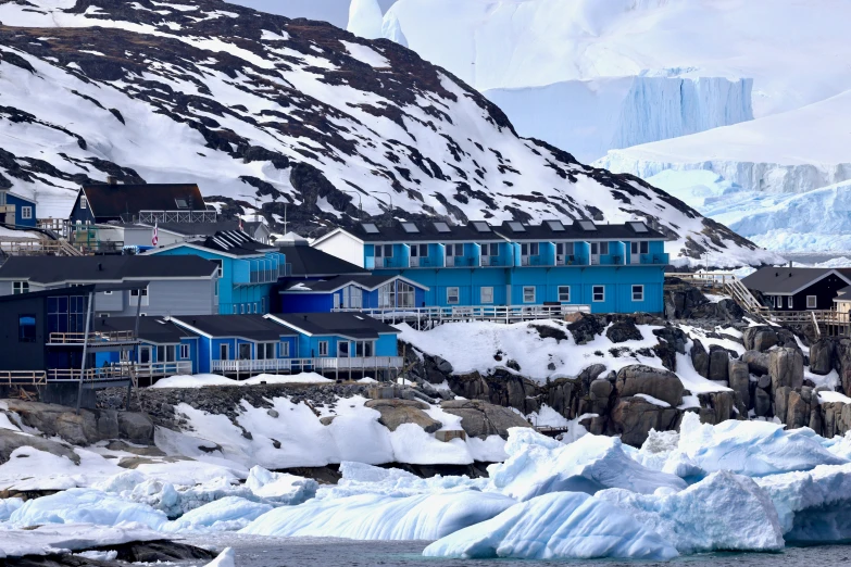 a mountain with some icebergs floating next to it