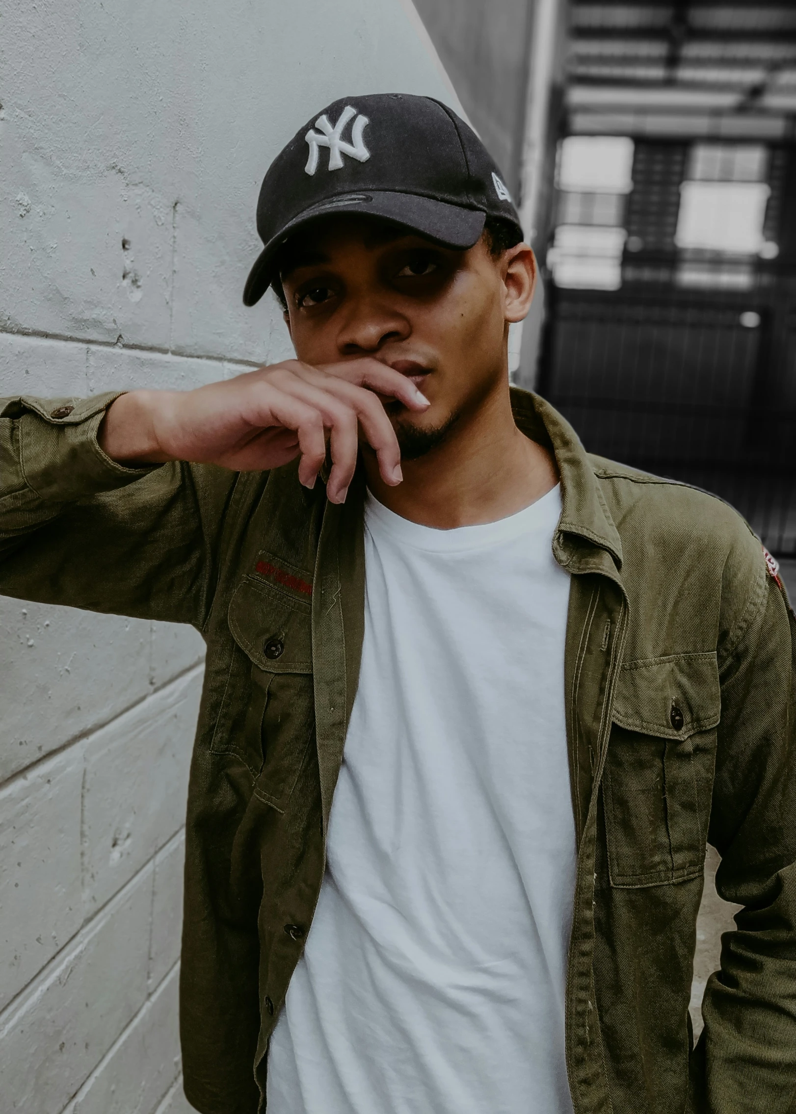 man standing in front of white wall in urban setting