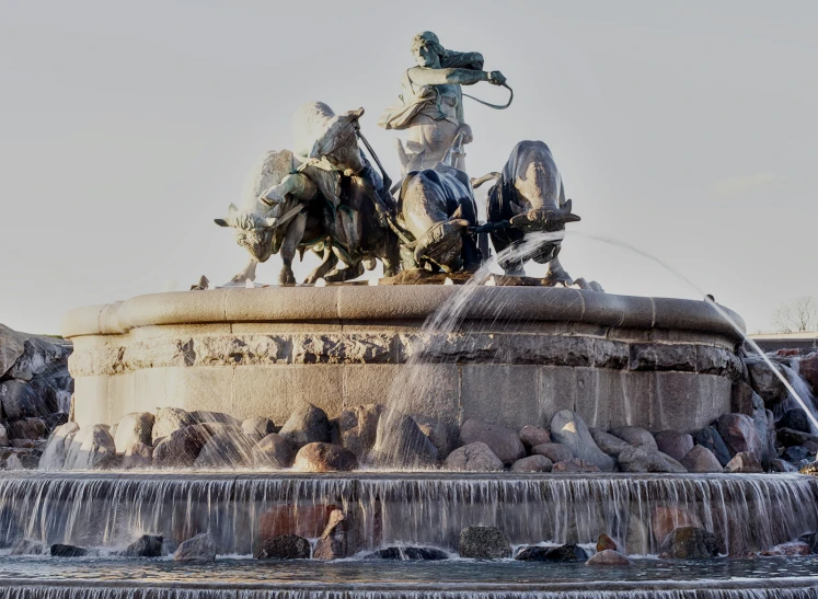 the fountain has many statues and flowing water