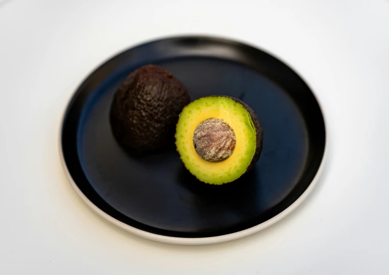 a round plate holds two pieces of fruit