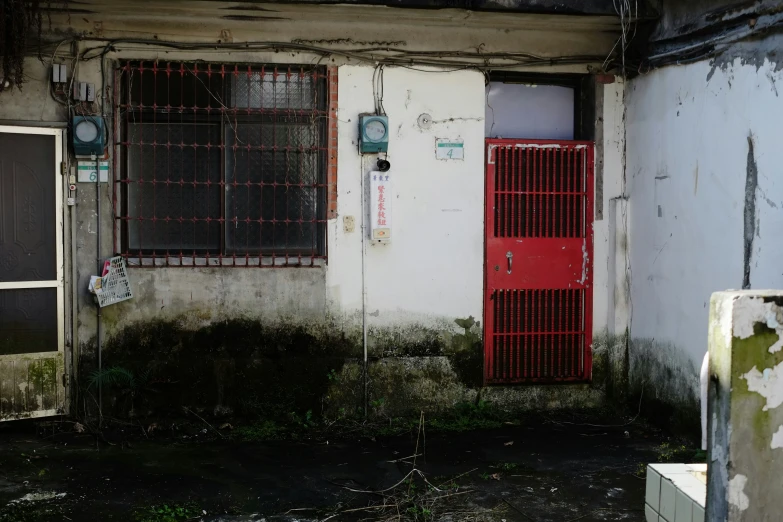 an old run down building with a red door