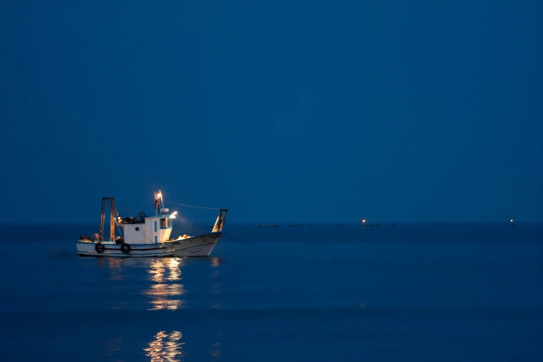 a boat is sitting at night on the water