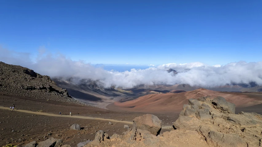 the mountains are surrounded by clouds in the distance