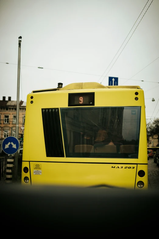 there is a bright yellow bus stopped at the stop