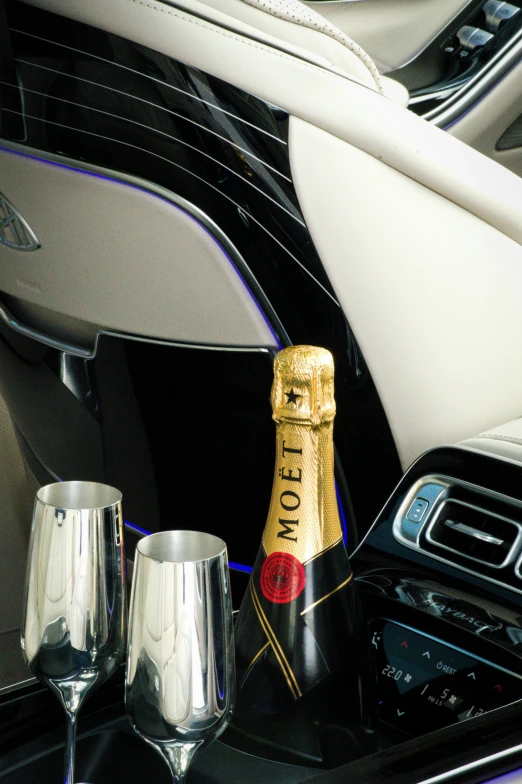 a wine bottle and two champagne glasses on a counter