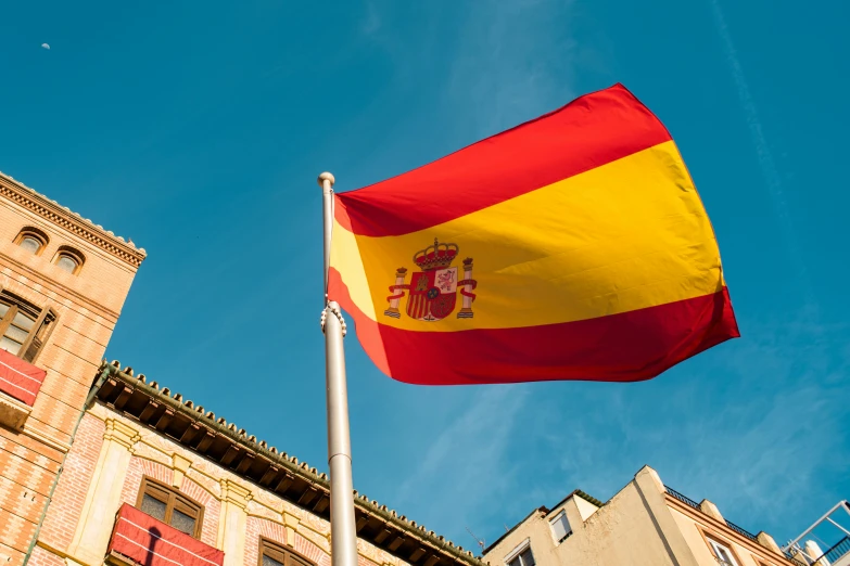 a flag on a pole flies high up in the sky