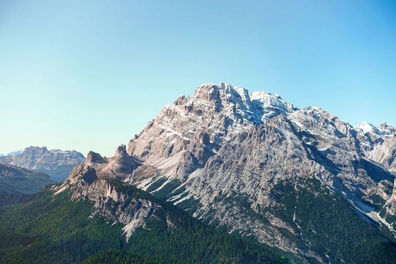 mountains are shown with snow on them and evergreens