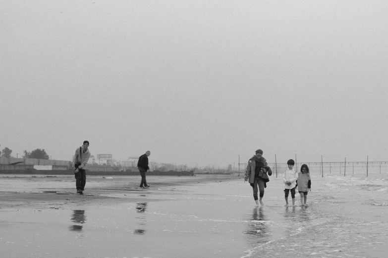 a few people on the beach walking around the water