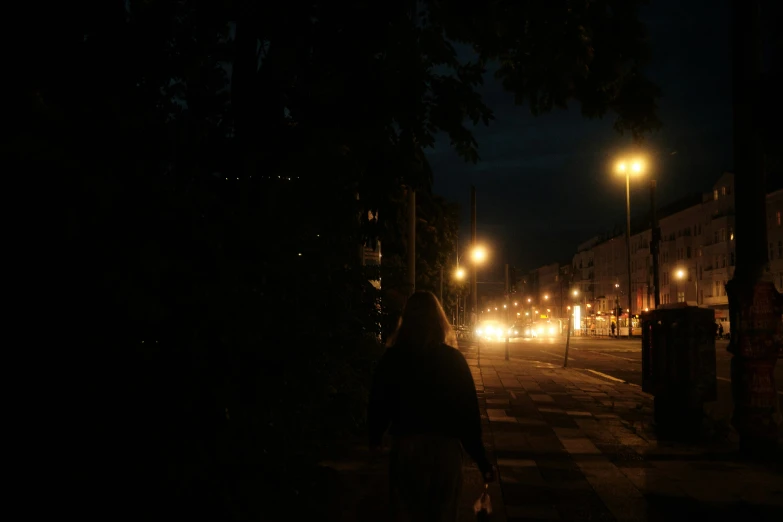 a woman walking down the street at night