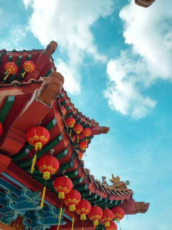 several red lanterns hang from the roof of a building