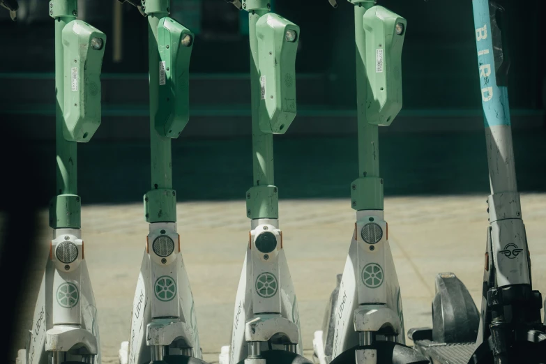 there are four green parking meters with wheels