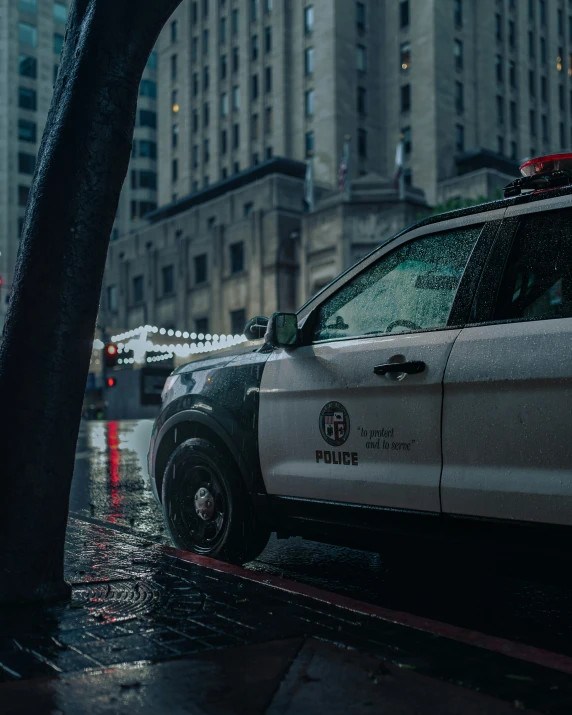 a police car parked in the rain in a city