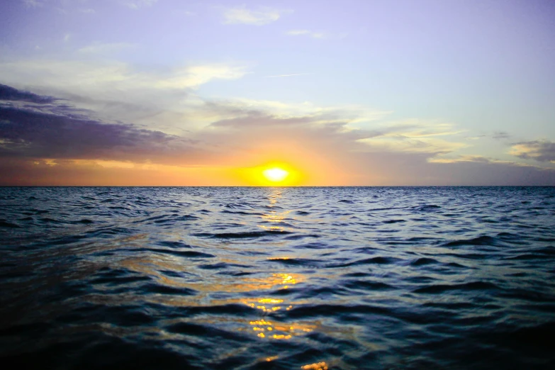 a sunset view from a sailboat of the ocean