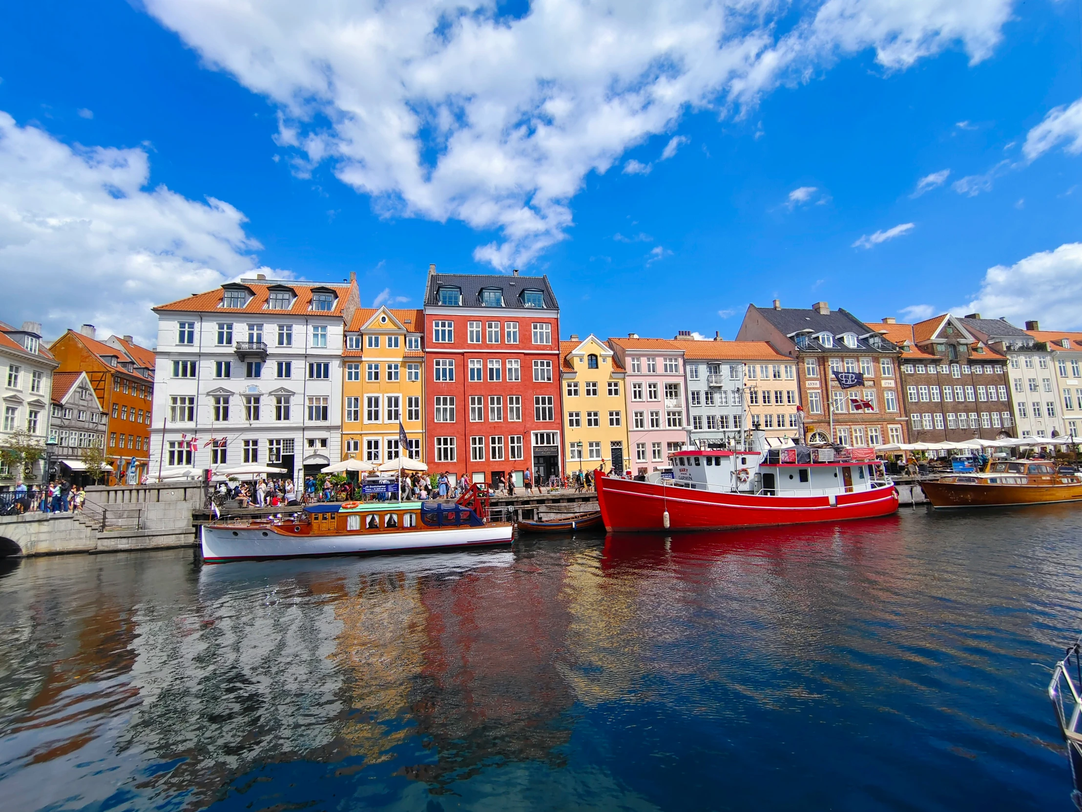 several boats sit on the water of a city