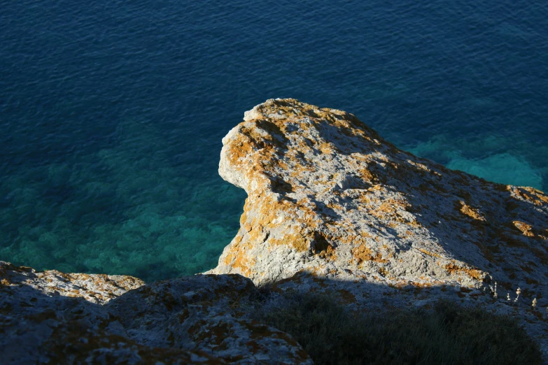 a man climbing a steep hill next to the ocean