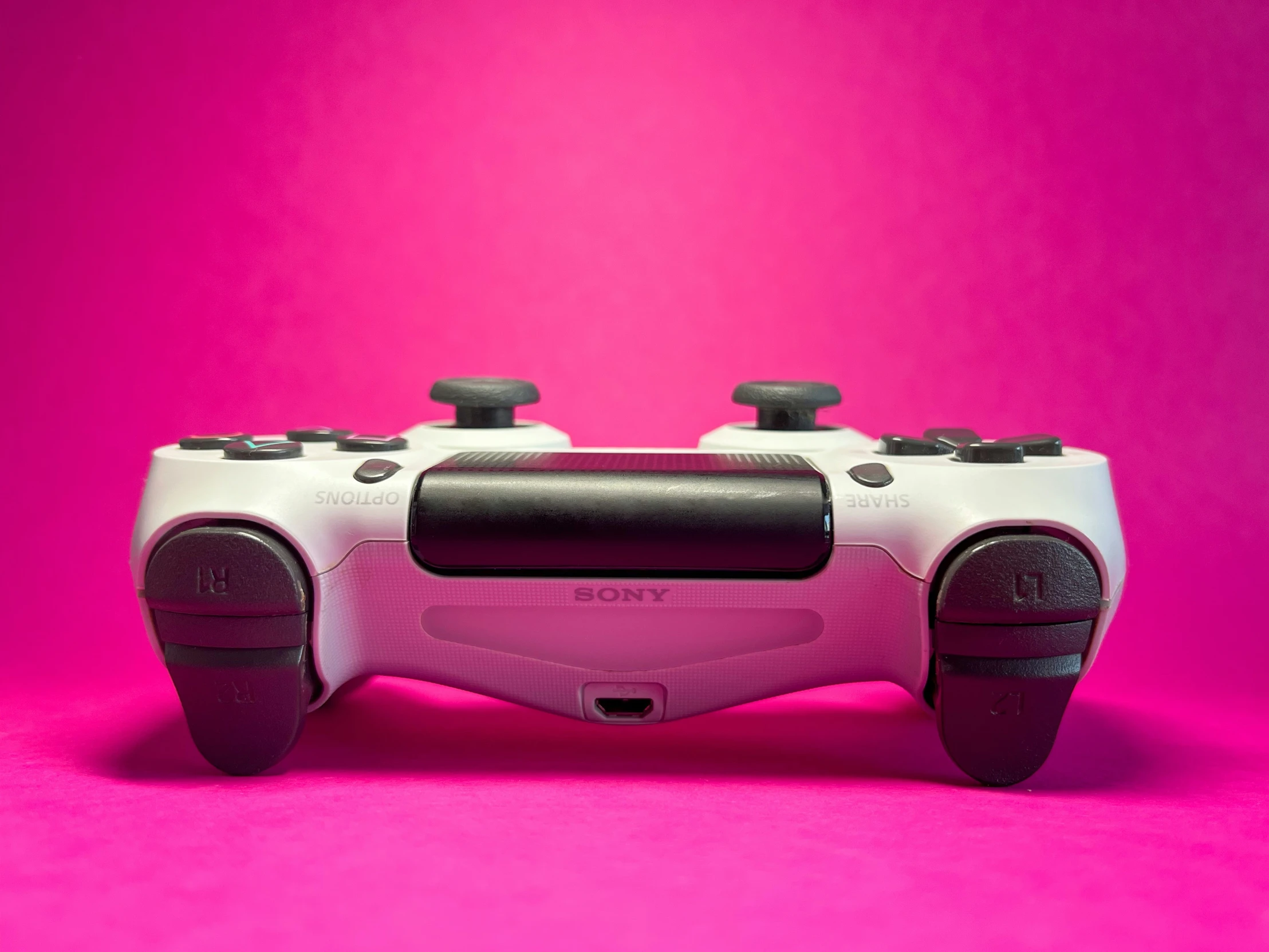 a very pretty video game controller on a pink background