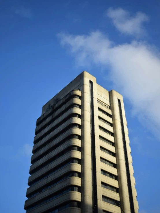 a tall building under blue sky with clouds