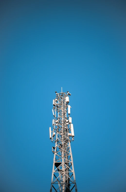 a very tall tower with many cellular towers on top