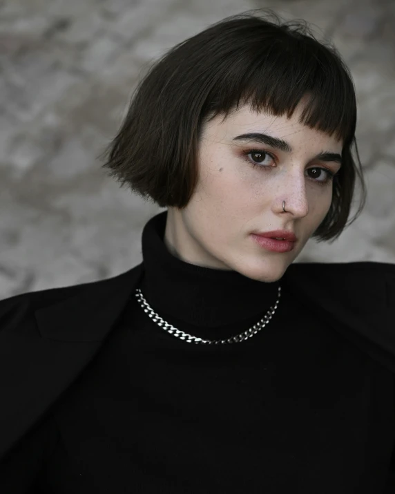 a woman with dark hair and wearing a collar