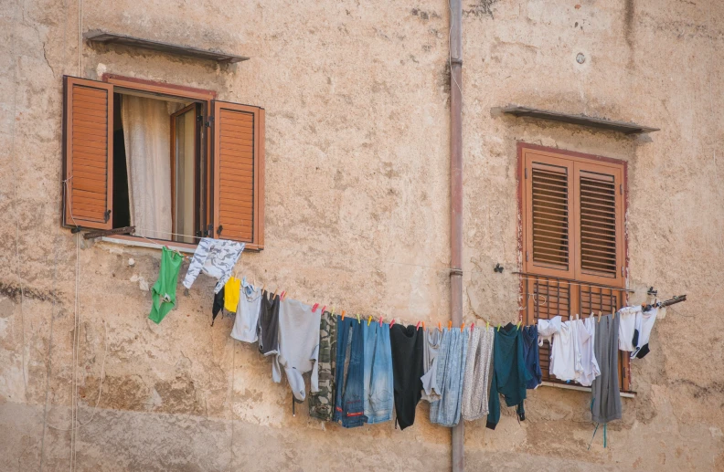 a clothes line with clothes hanging out to dry in front of a house