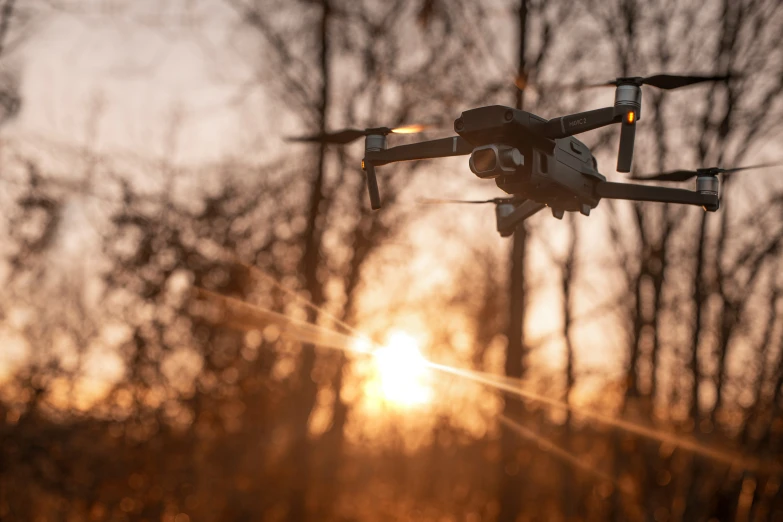 a large quad camera helicopter taking flight in the sunset