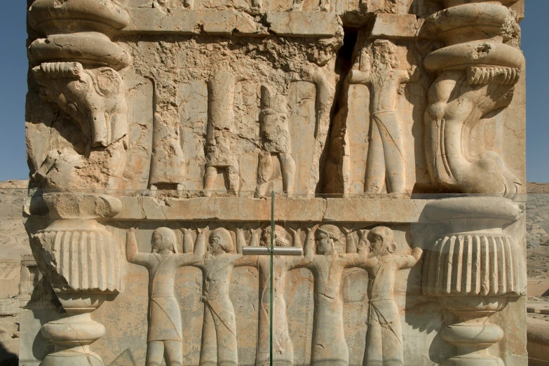 several large statues on the side of a stone building