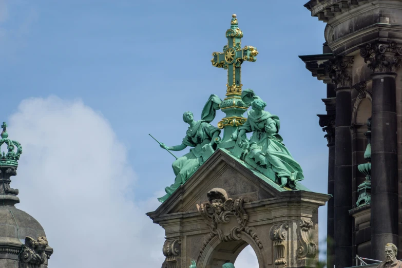 statue and column atop a building with the sky in the background