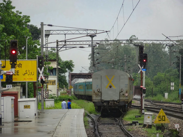 a train going down the tracks by a forest