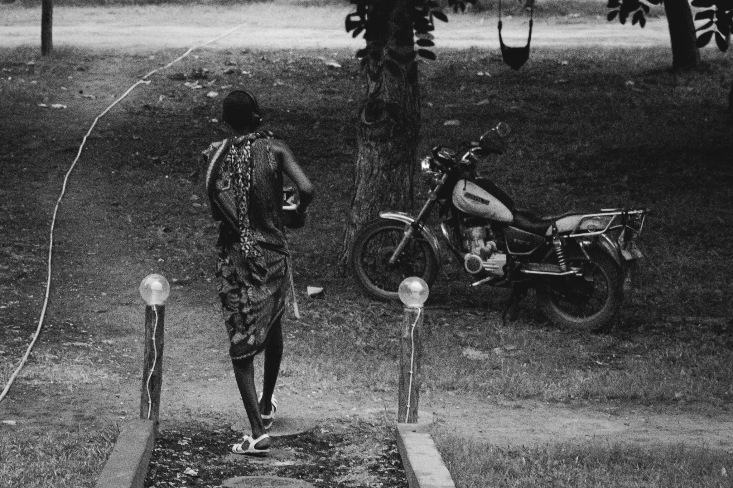 a person walks along the curb with his motorcycle on it