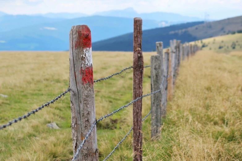 a wooden fence in the middle of a grass field
