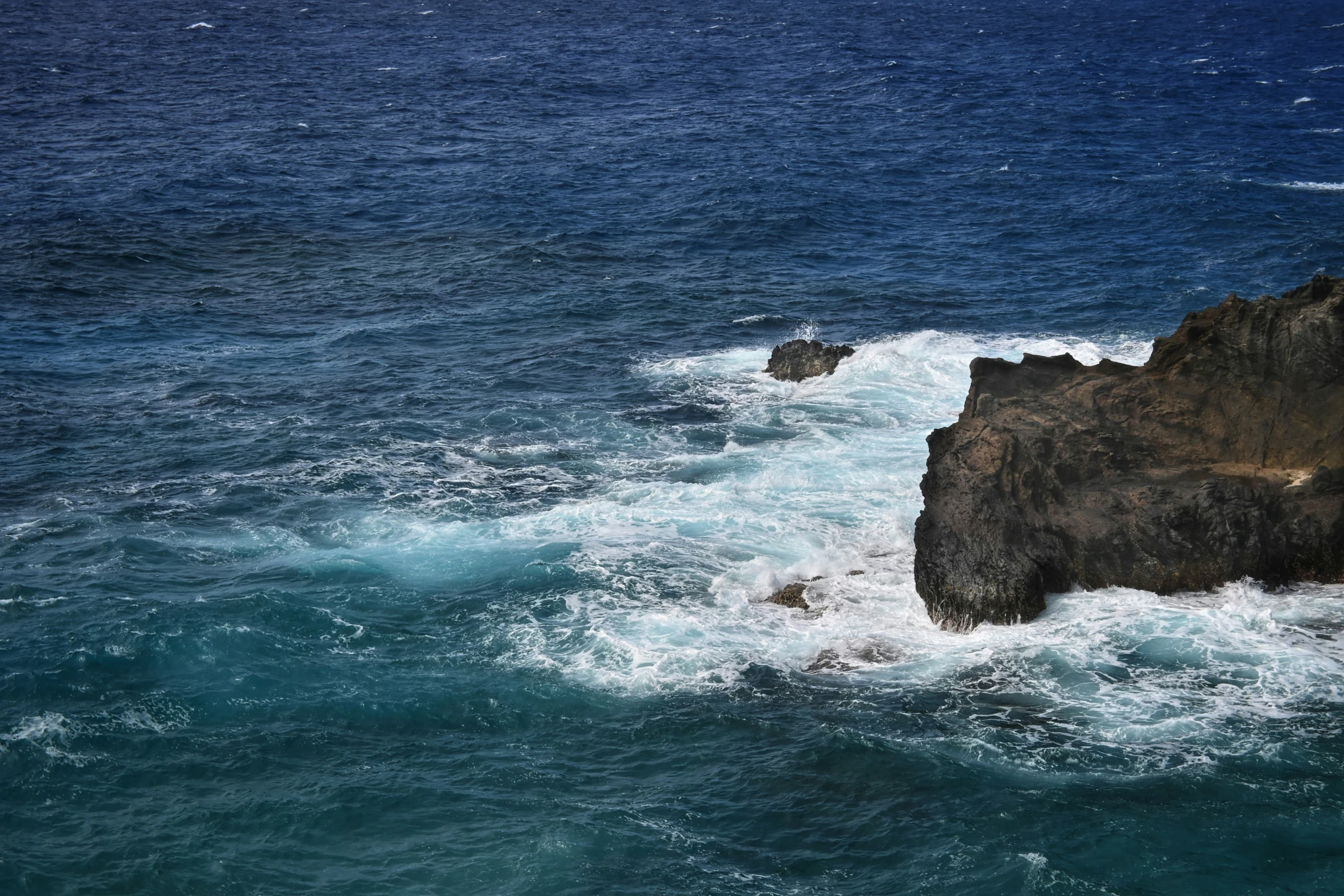 a rocky island with a body of water in front