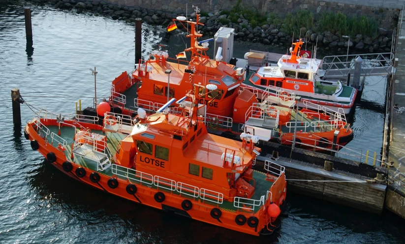 three orange boats are parked on the water