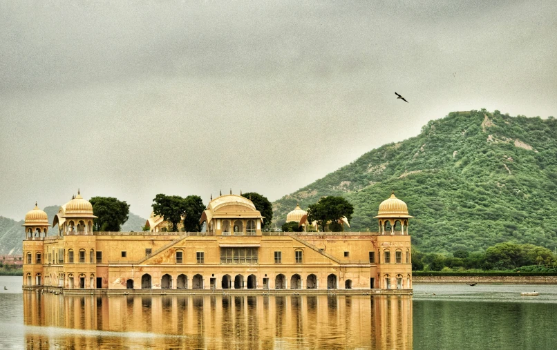 a large, old palace is surrounded by greenery