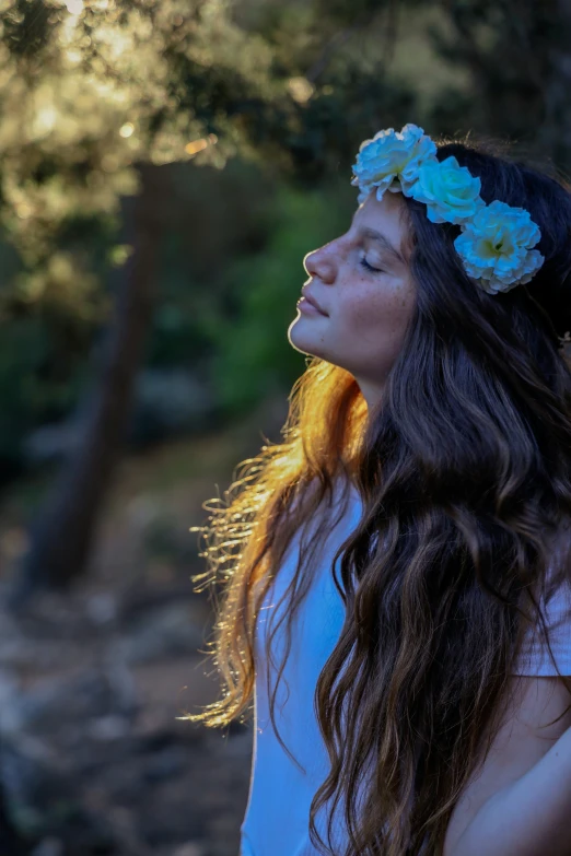 a beautiful woman with her eyes closed standing outdoors