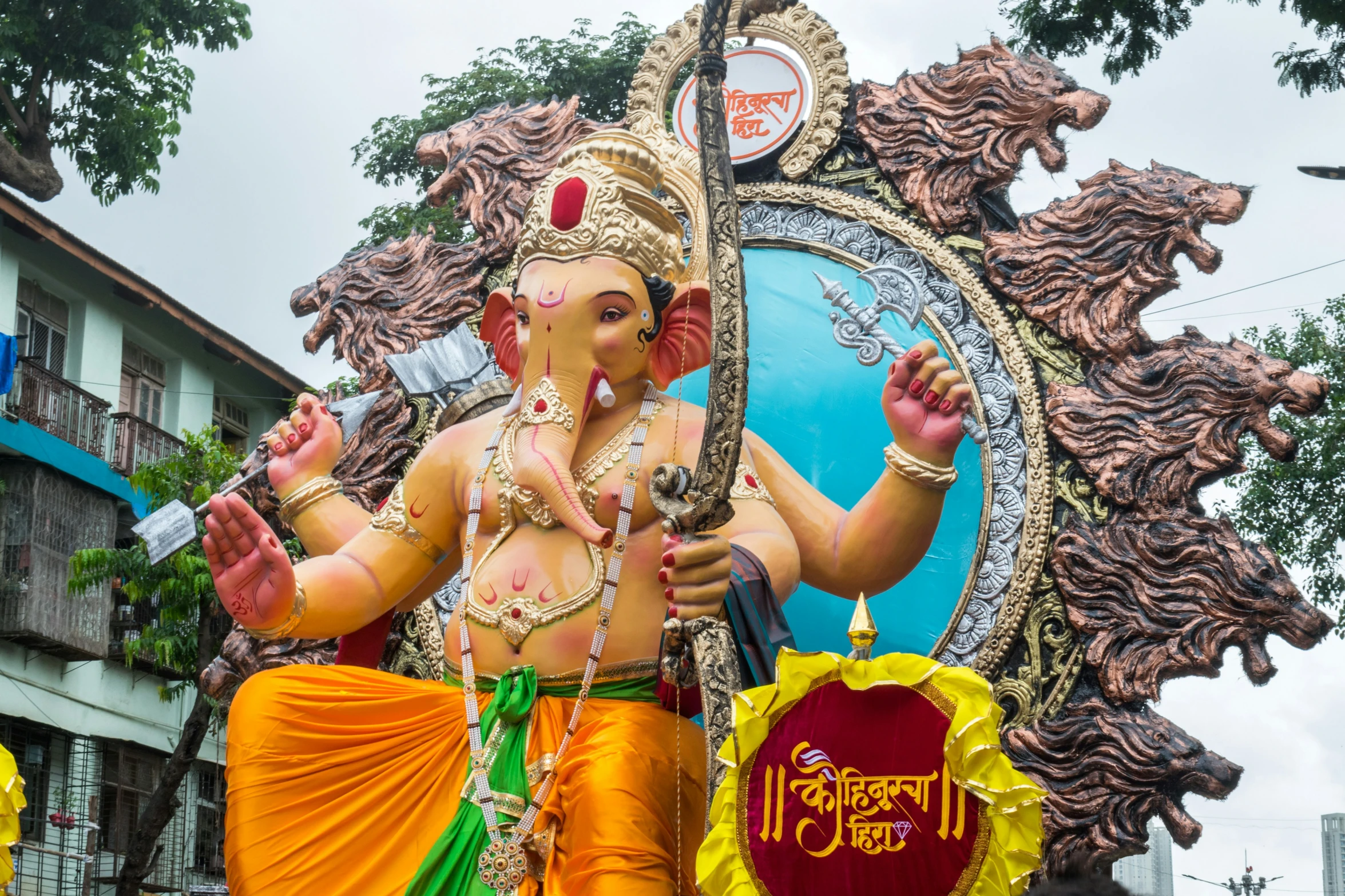 a statue of an indian god in front of an elaborate building