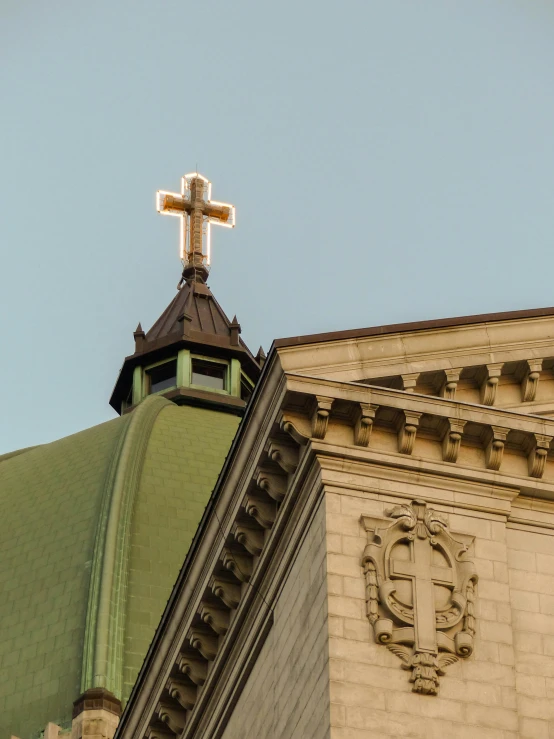 a cross stands over the top of an old building