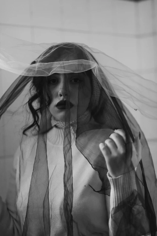 a woman in a veil and shirt wearing a sweater