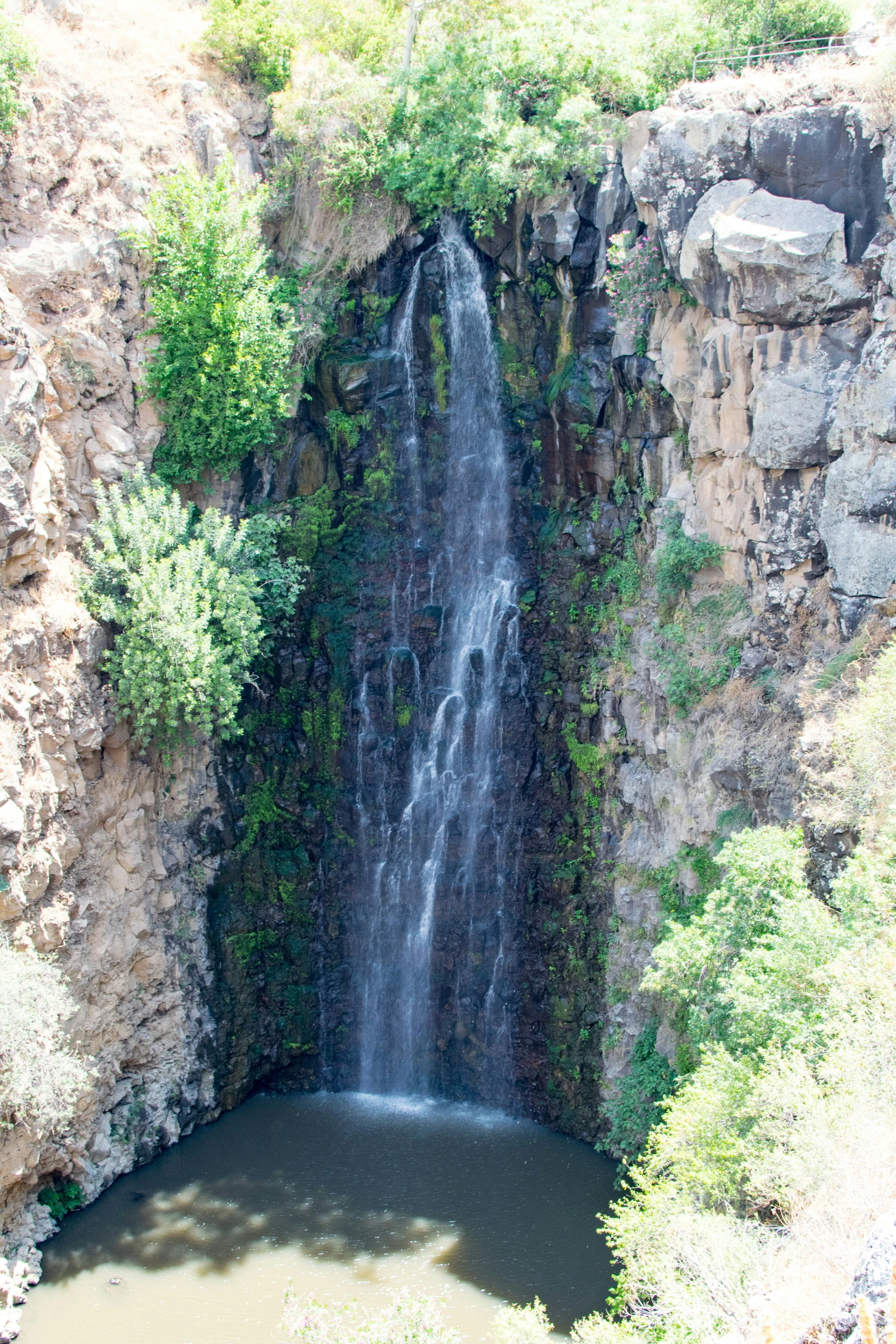 a large waterfall is coming out of a cliff into the water