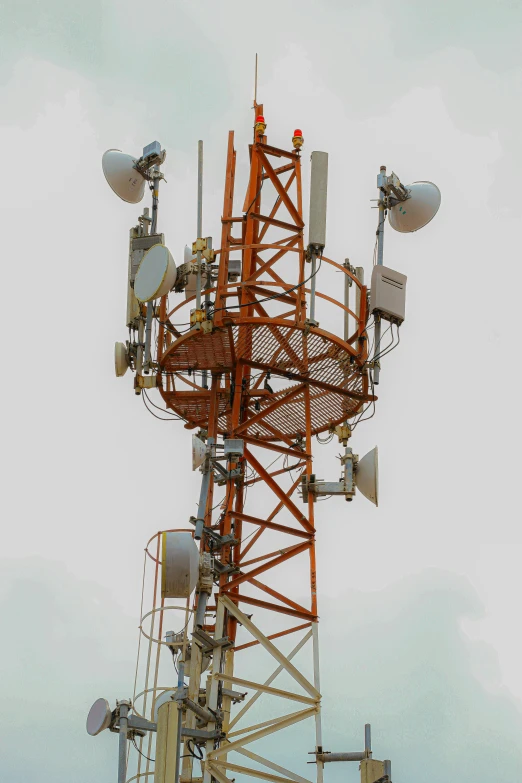 a large tower with many antennas against a gray sky