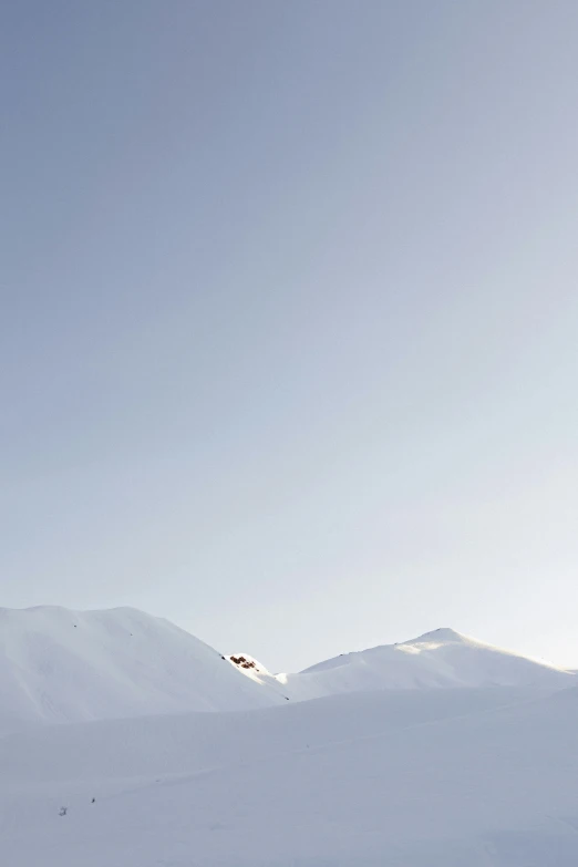 people skiing on a snow covered mountain under a blue sky