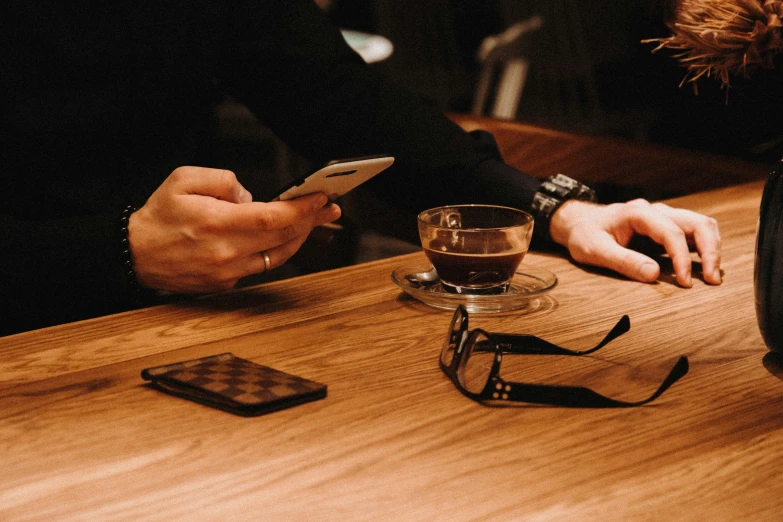 a person sitting at a table looking at their phone