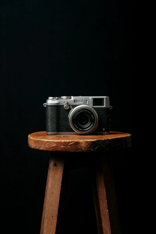 an old camera on top of a wooden chair