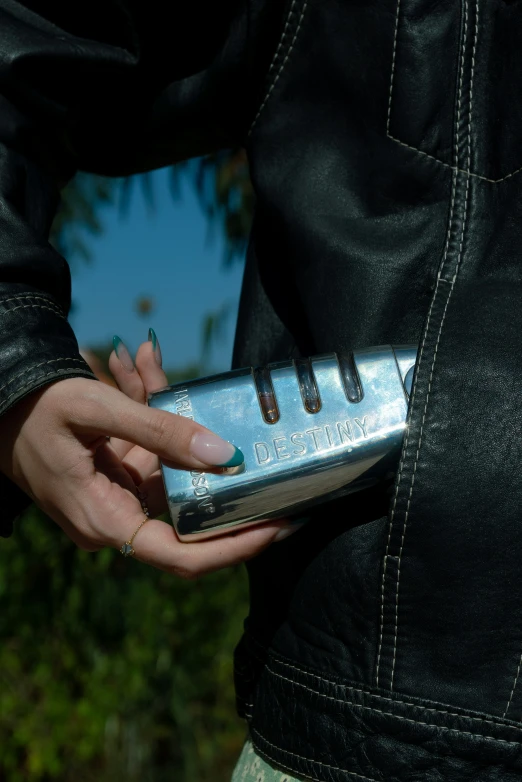 a person's hand holding onto a metal piece