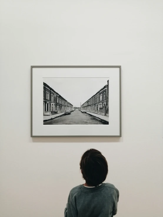 a child is staring at a pograph in the center of a room